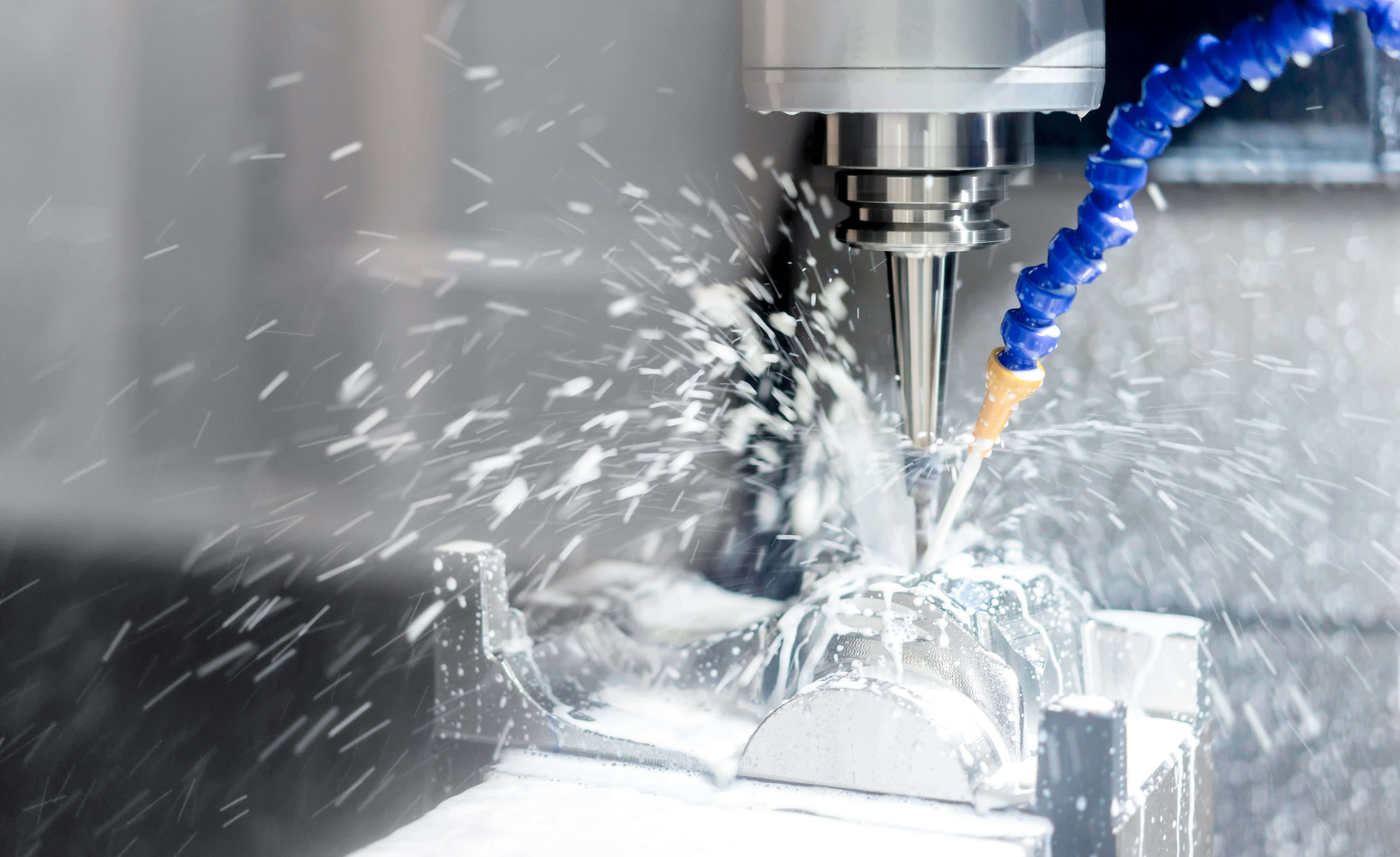 CNC milling machine processing aluminum parts with coolant